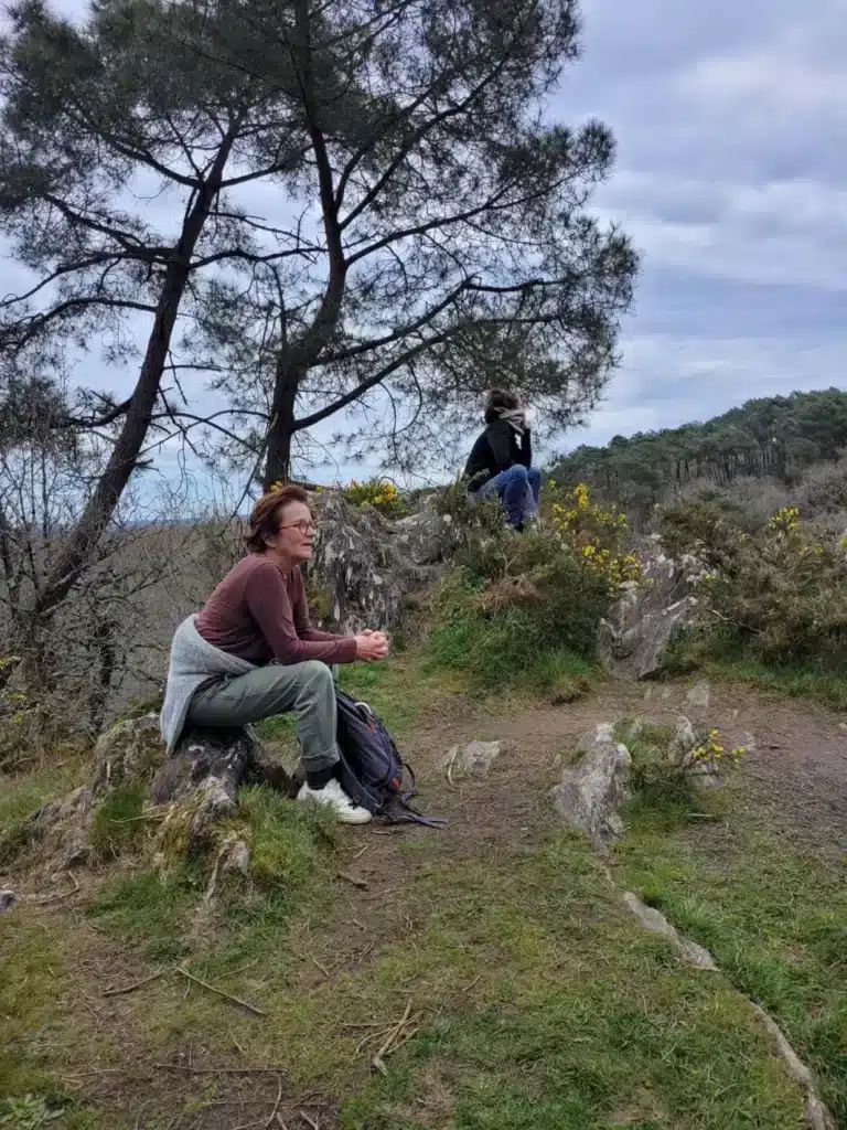 Deux personnes assises dans la nature, près d'un arbre.
