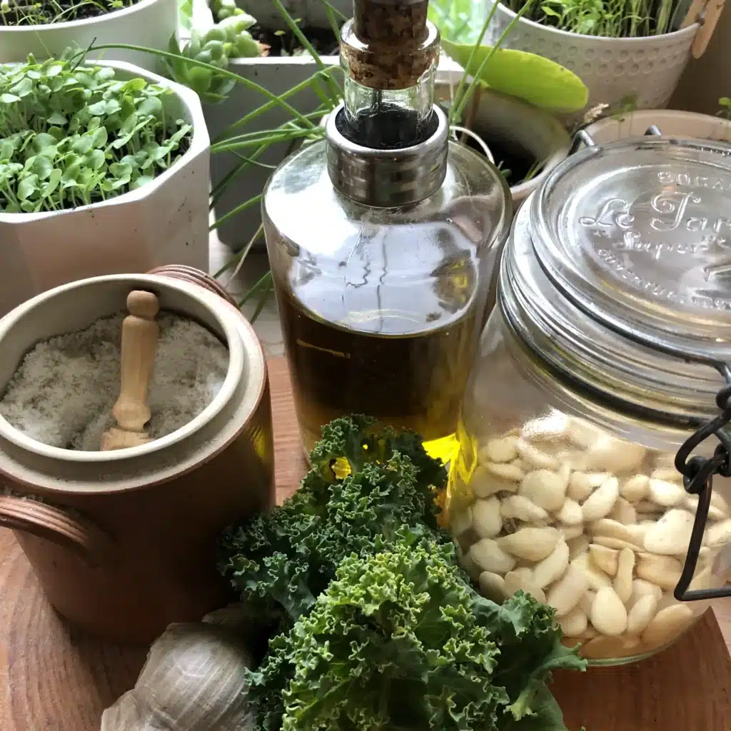 Ingrédients de cuisine : ail, huile, sel, kale, plantes.