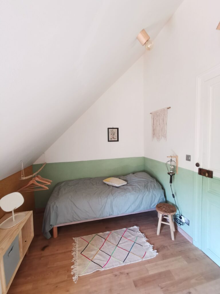 Petite chambre mansardée avec lit simple et déco minimaliste